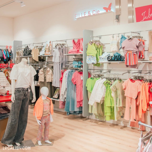 Section "Fille & Cie" du magasin Zapperlipopette, avec des vêtements colorés et tendance pour filles, exposés sur des cintres et mannequins.