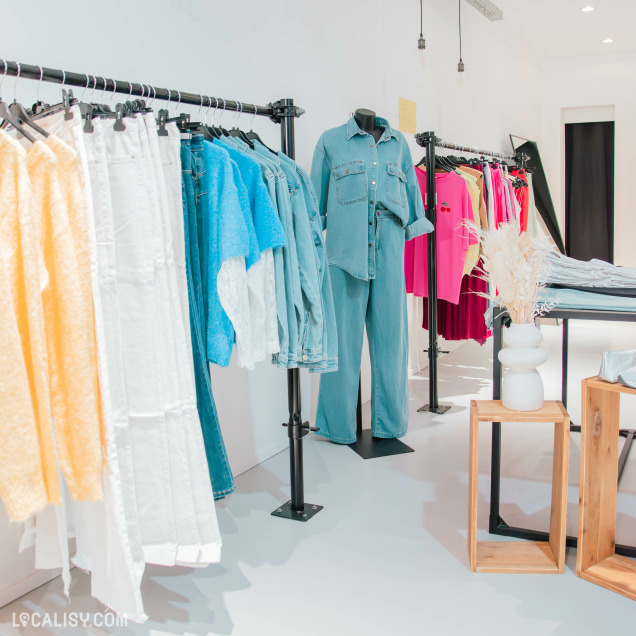 Sélection de vêtements en jean et tenues décontractées exposées dans le magasin Neo Store à Huy.