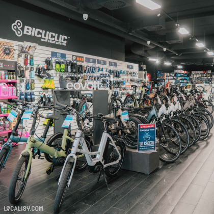 Intérieur du magasin Bicyclic Bike Shop à Liège avec une large sélection de vélos électriques et équipements.