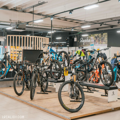 Une section mettant en avant des VTT suspendus et exposés sur des supports pour faciliter leur visibilité. Des modèles aux cadres robustes et aux pneus larges témoignent d’une offre adaptée aux amateurs de sensations fortes. Le décor moderne et organisé du magasin met en valeur chaque catégorie de vélos.