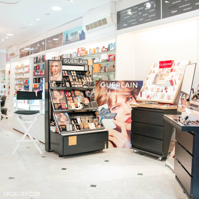 Présentoirs de maquillage des marques Guerlain et Clarins à l’intérieur du magasin de parfum Audrey à Fléron.