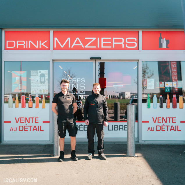Équipe de la Brasserie Maziers à Marche-en-Famenne posant devant l’entrée du commerce de boissons.