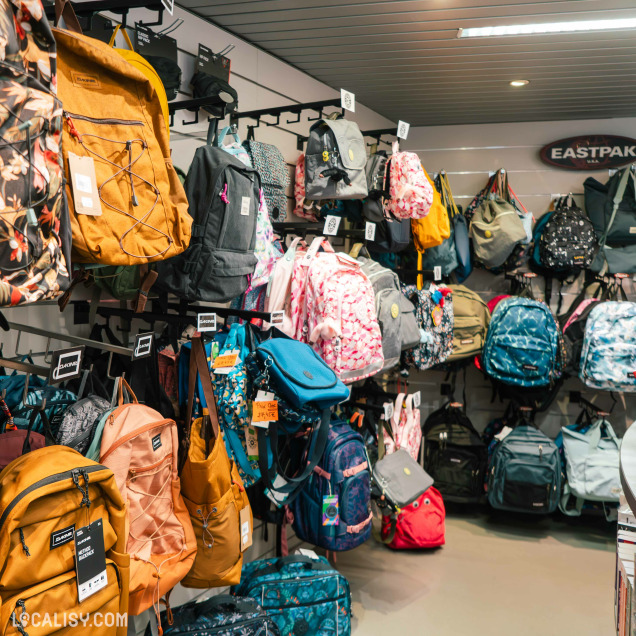 Vue d’ensemble d’un magasin de papeterie, montrant plusieurs rayons garnis de fournitures scolaires, carnets, crayons de couleur, accessoires de dessin et produits de loisirs créatifs.