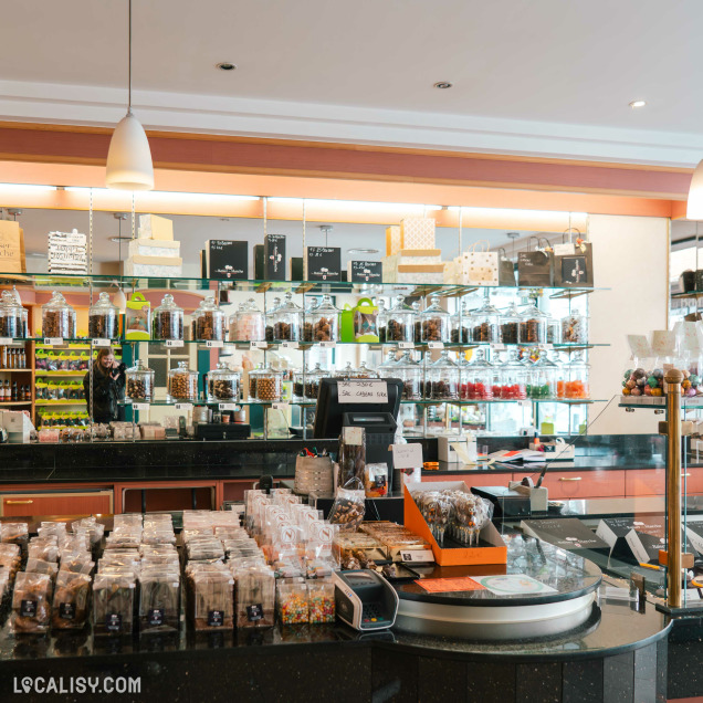 Intérieur de la boutique Au Baiser de Marche à Marche-en-Famenne, avec chocolats et confiseries.