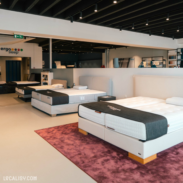 Espace d’exposition du magasin Beds & Interiors à Liège avec des lits de la marque Auping.