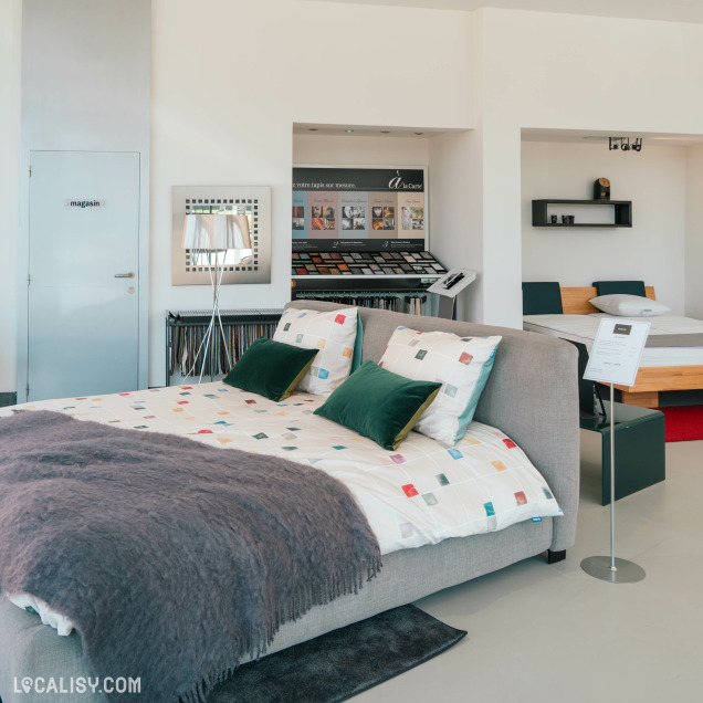 Chambres et lits décorés avec textiles exposés chez Beds & Interiors à Liège.
