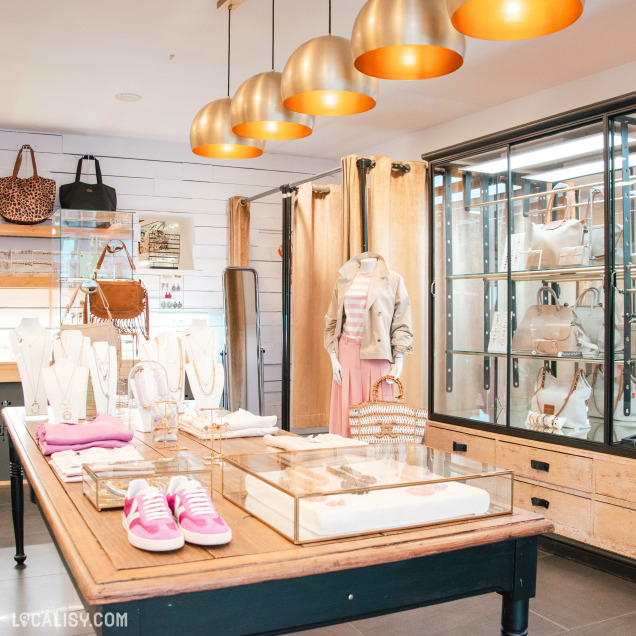 Vêtements, sacs et bijoux exposés dans la boutique Les Filles à Visé.
