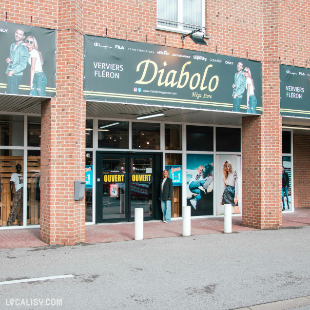 Vue extérieure de la façade du magasin avec affiches promotionnelles et entrée principale.