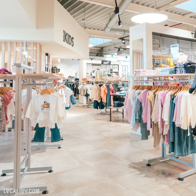 Intérieur du commerce de vêtements Espace Mode à Nandrin avec rayons pour femmes.