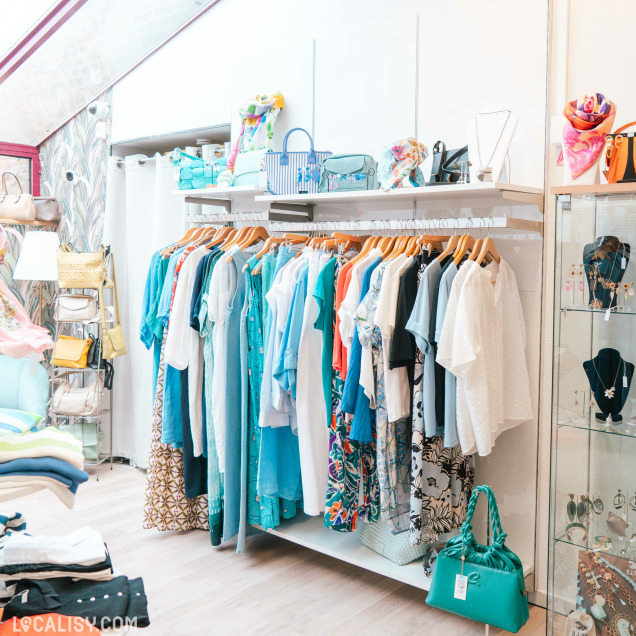Vêtements aux tons bleus et accessoires exposés chez Doula à Marche-en-Famenne.
