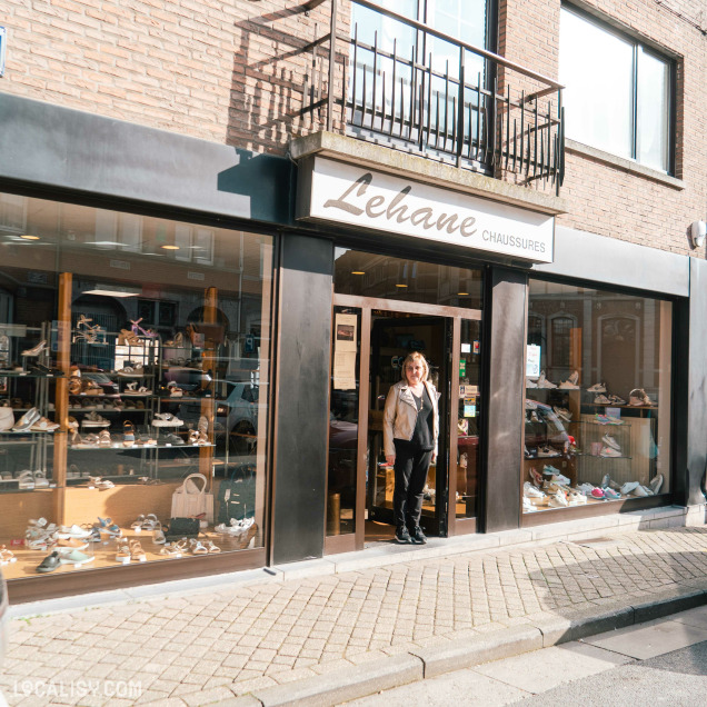 Commerce de chaussures Lehane à Herve vu de l’extérieur avec sa vitrine et une vendeuse souriante à l’entrée.