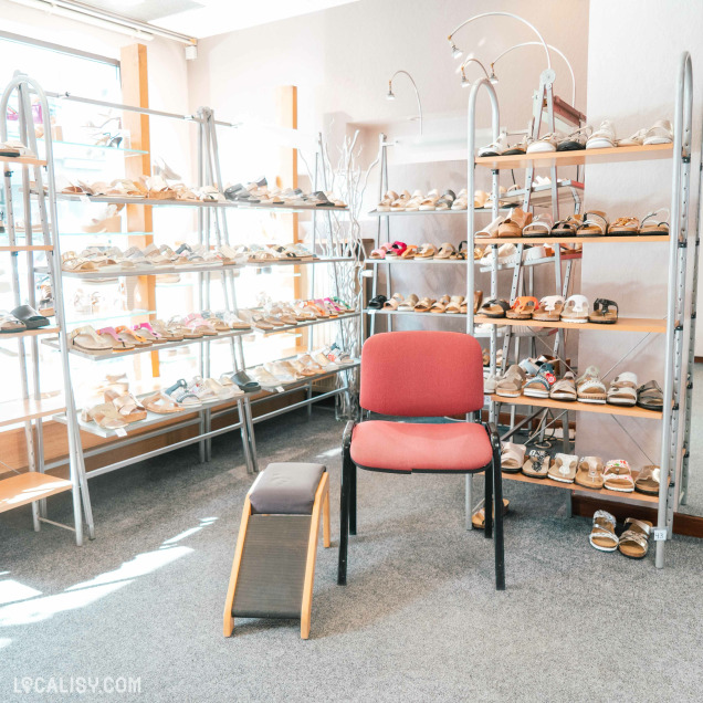 Commerce de chaussures Lehane à Herve présentant des sandales sur étagères avec un espace d’essayage.