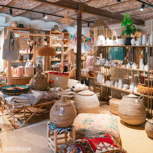 Intérieur du commerce de décoration L'Ane au Salon à Berneau avec objets artisanaux et paniers.