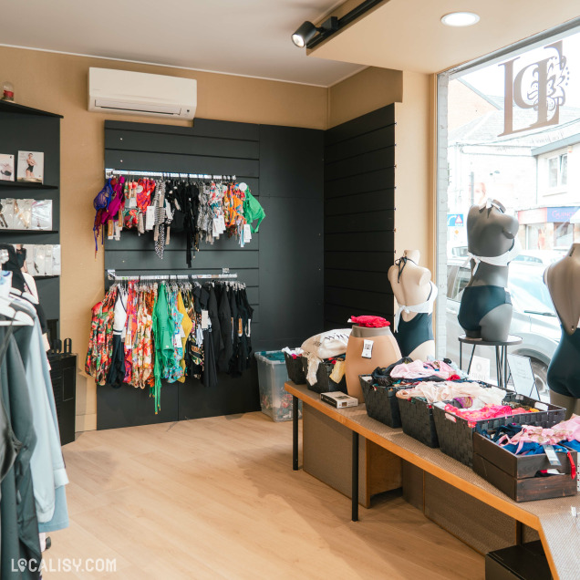 Intérieur du magasin de lingerie La pince à Linge à Wanze avec des présentoirs de maillots de bain et lingerie.