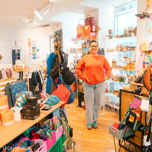 Gérante du concept store Ultra Bien à Huy posant devant les rayons de produits.