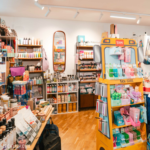 Intérieur du concept store Ultra Bien à Huy, présentant des sacs à main et des produits de beauté.