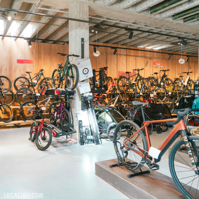 Vue large de l'intérieur du magasin de vélos Kameo Bikes à Liège avec une grande variété de vélos exposés.