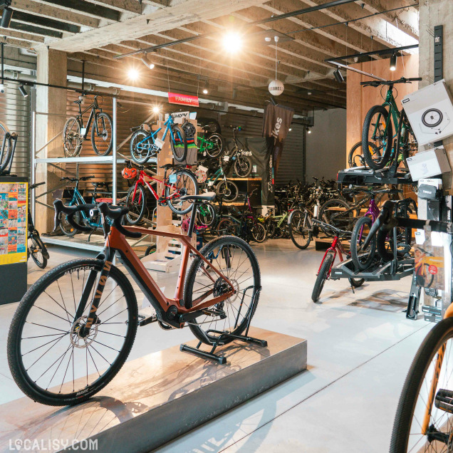Intérieur du magasin de vélos Kameo Bikes à Liège, présentant des vélos de ville et des accessoires.