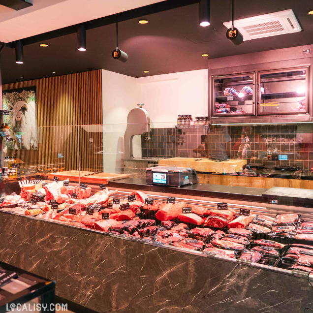 Comptoir de la boucherie Debruge - Halle de l'Artisan à Chênée exposant diverses coupes de viande.