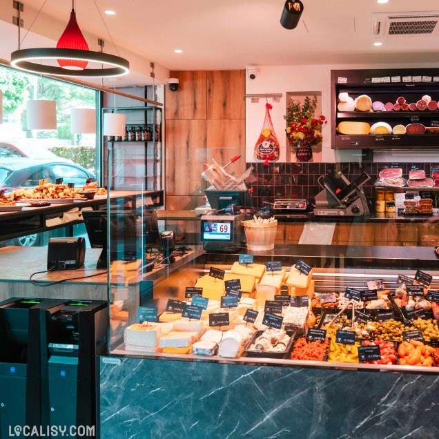 Comptoir de la boucherie Debruge - Halle de l'Artisan à Chênée rempli de fromages et de produits traiteur.