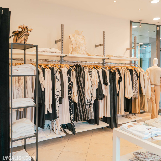Rayons de vêtements noirs et blancs dans la Boutique Georgette à Huy.