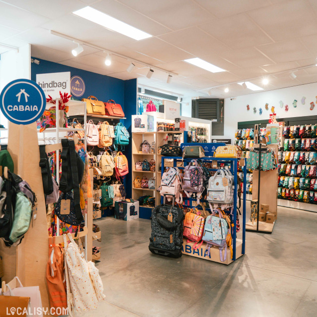 Intérieur du magasin Boya Concept Store à Theux, avec des sacs à dos et un mur de chaussettes.