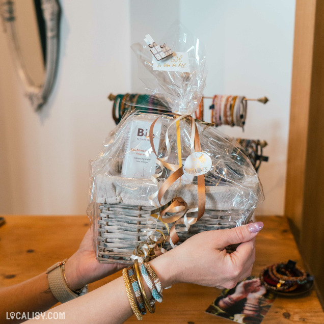 Deux mains tenant un panier cadeau de l'institut Les Citadines à Marche-en-Famenne.
