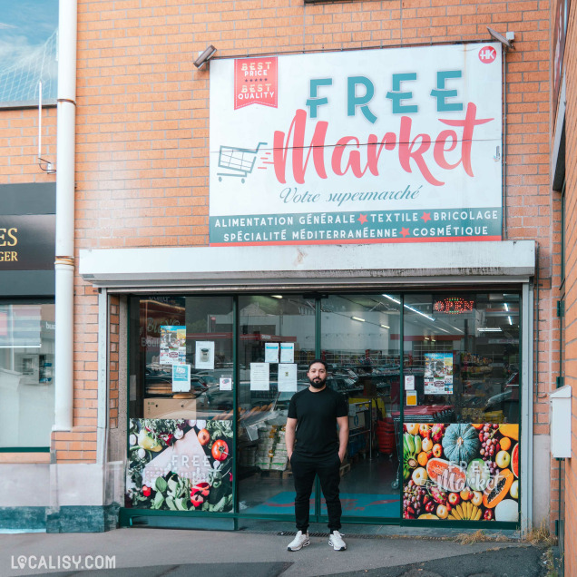 Magasin d’alimentation Freemarket à Verviers, photo de la devanture avec le gérant.