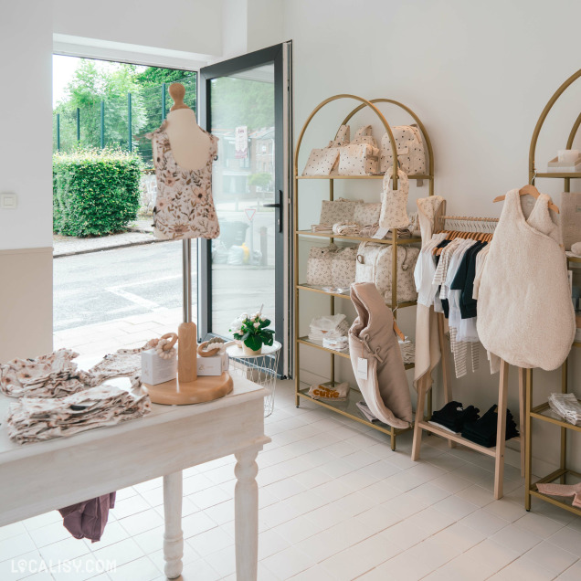 Entrée du magasin de vêtements pour enfants Elima Eliott + Maman à Jupille, avec des vêtements et accessoires.