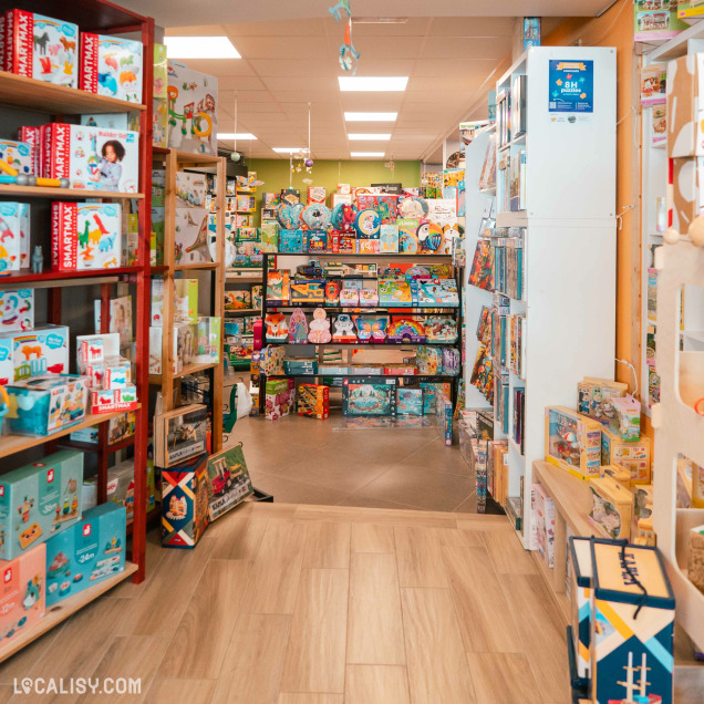Section du magasin de jouets La poule aux jeux d'or à Rochefort avec des livres, des jeux et du matériel artistique.