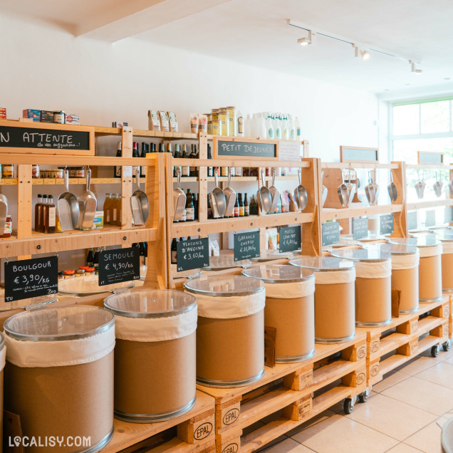 Allée du magasin Vrac&Vous à Rochefort, montrant des bacs de produits en vrac et des étagères.