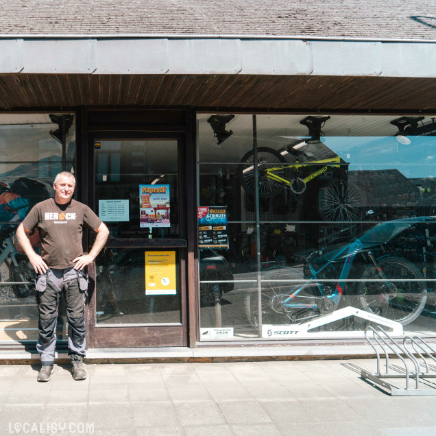 Façade du magasin de vélos CycleSport à Rochefort, avec un homme posant devant.