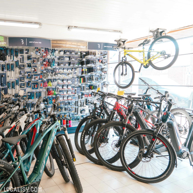 Intérieur du magasin de vélos CycleSport à Rochefort, exposant des vélos et des équipements muraux.