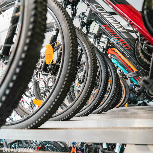 Gros plan sur les roues de vélos alignées dans le magasin CycleSport à Rochefort.