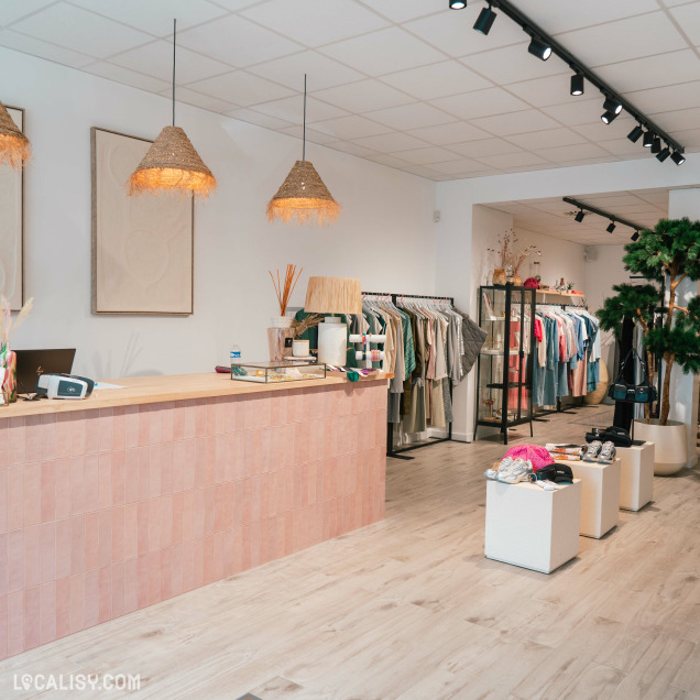 Portants de vêtements et accessoires chez Agathe à Visé, commerce de prêt-à-porter féminin.