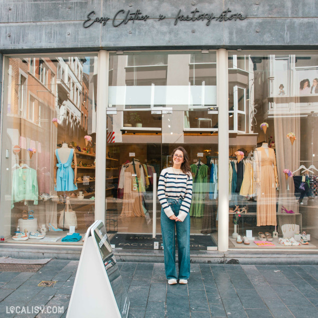 Façade du magasin de chaussures et de vêtements Factory Store à Liège, avec une personne posant devant l'entrée.