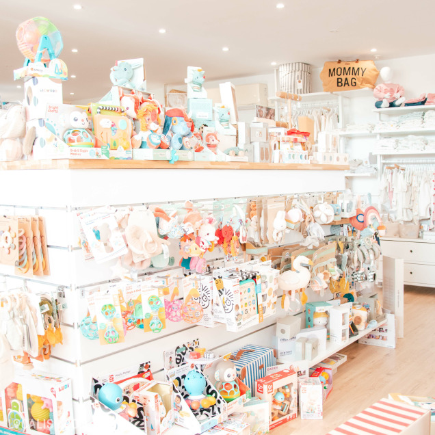 Vêtements pour bébés et accessoires empilés ou suspendus sur les étagères du magasin Baby Store à Nandrin.