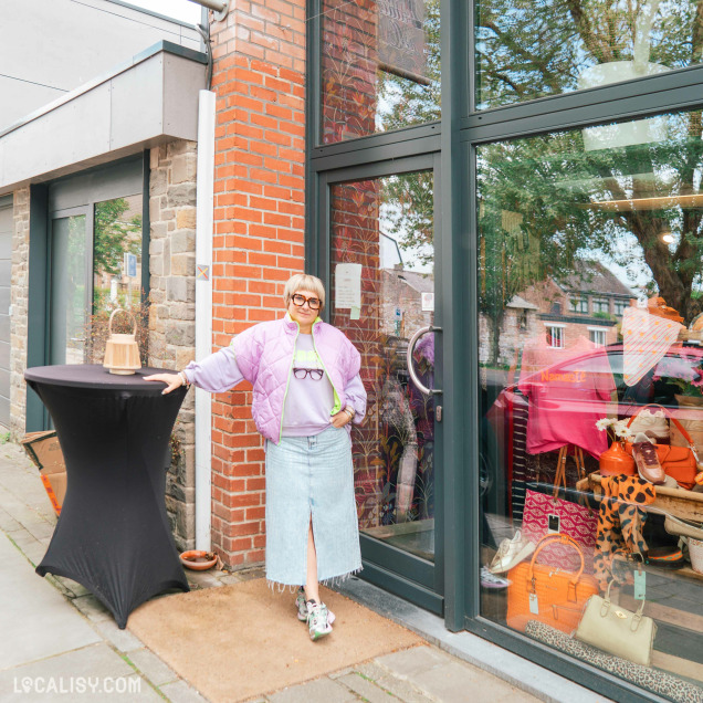 Façade extérieure du magasin de chaussures Addict de C à Theux, avec une personne posant devant la vitrine.
