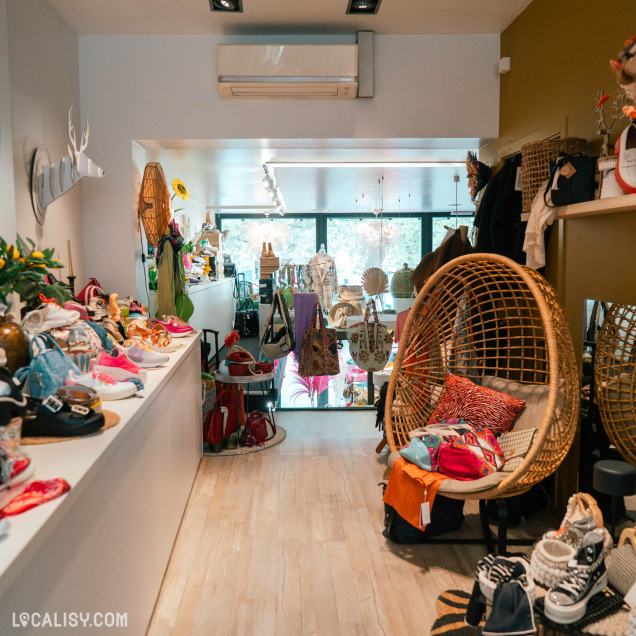 Vue intérieure du magasin Addict de C à Theux, montrant des chaussures, accessoires et des articles de décoration.