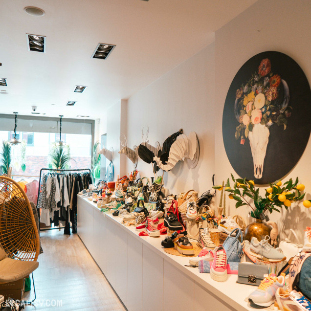 Longue étagère remplie de chaussures variées et d'accessoires dans le magasin Addict de C à Theux.