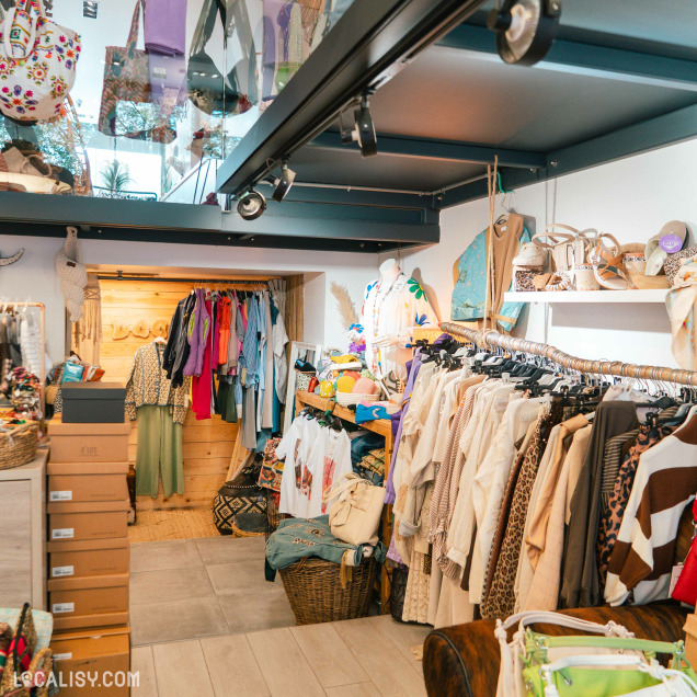 Intérieur du magasin Addict de C à Theux, présentant des vêtements et chaussures suspendus et exposés.