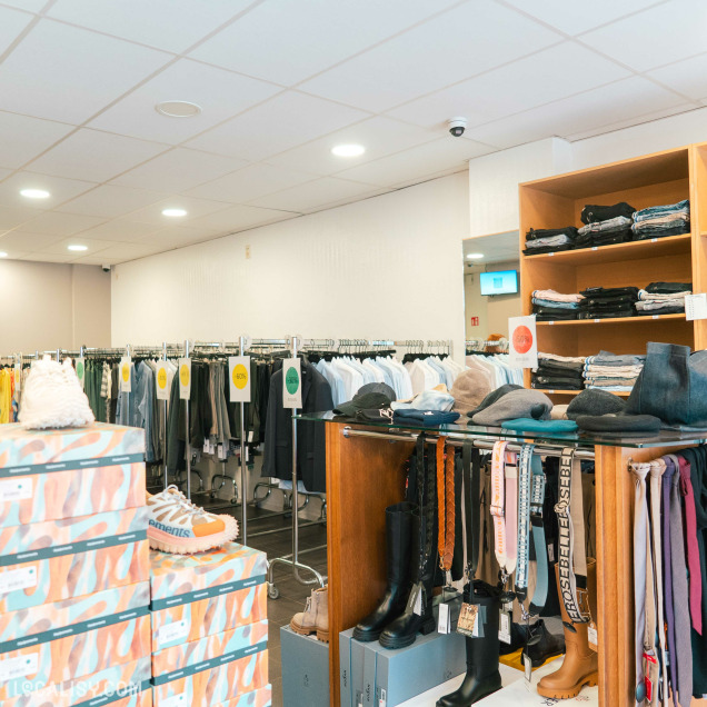 Intérieur de la boutique Au Fuseau Suite à Spa, avec des accessoires de mode et une collection de vêtements pour femmes.