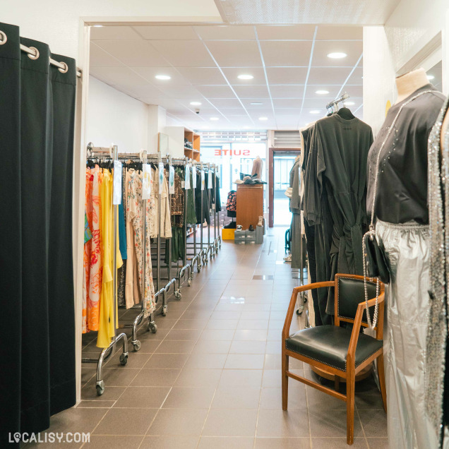 Vêtements de grandes marques pour femmes sur des portants et des étagères au magasin Au Fuseau Suite à Spa.