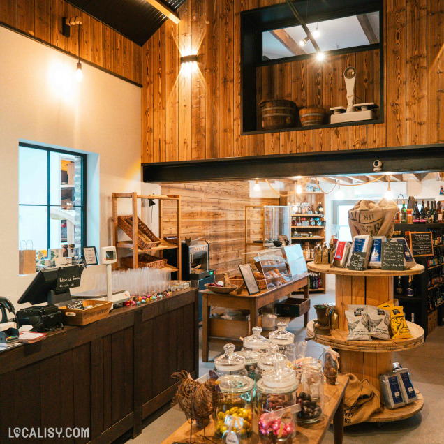 Un charmant espace de vente mêle tradition et authenticité avec ses murs en bois, ses étals garnis de douceurs artisanales et son ambiance chaleureuse de commerce local.
