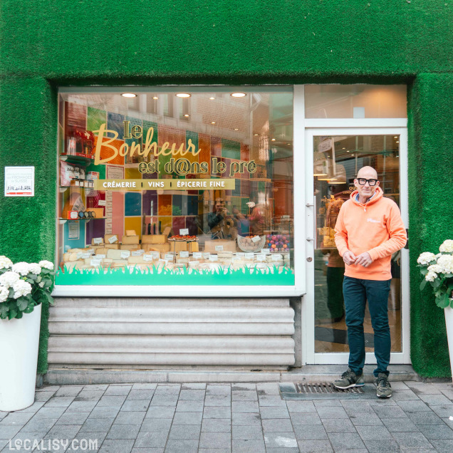 Façade de la crèmerie Le bonheur est dans le pré à Huy, avec des vitrines remplies de fromages.