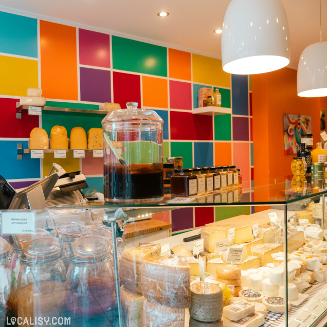 Assortiment de fromages et de produits d'épicerie fine dans la vitrine réfrigérée de la crèmerie Le bonheur est dans le pré à Huy.