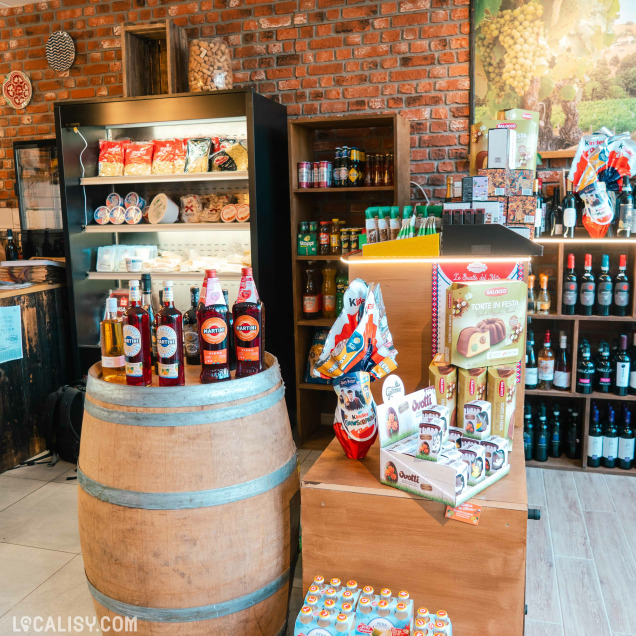 Baril de boissons, confiseries et étagères de vins dans l'épicerie italienne Les délices de Maria à Huy.