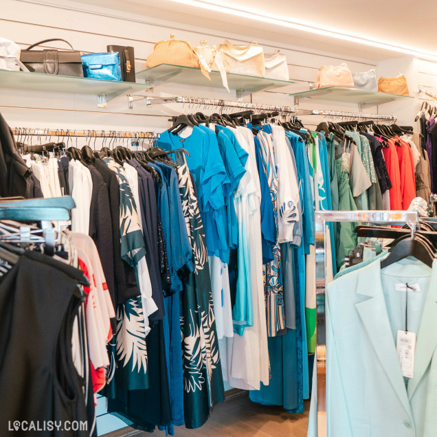 Intérieur du magasin de vêtements pour femmes Autrement Féminin à Nandrin, avec des portants et des étagères remplis.