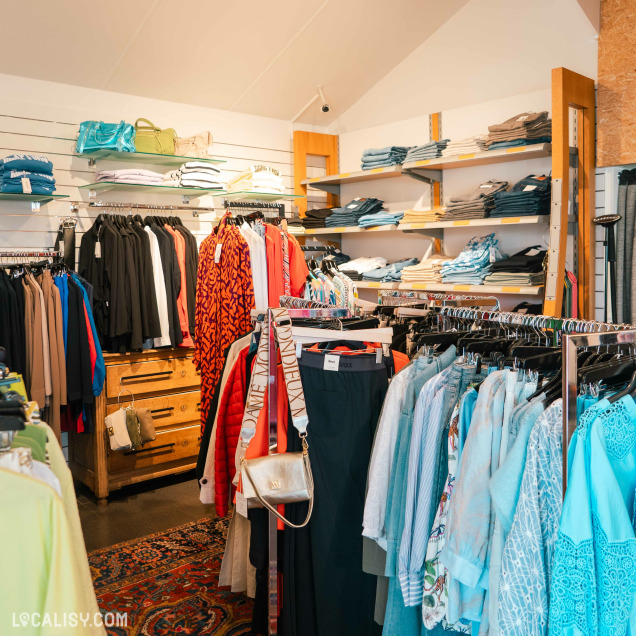 Allées de vêtements et d'accessoires de mode dans le magasin Autrement Féminin à Nandrin.