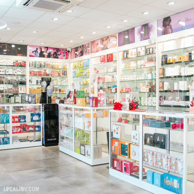 Intérieur lumineux d’une parfumerie moderne aux présentoirs en verre regorgeant de parfums de marques prestigieuses.